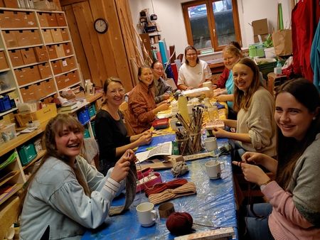 Eine Gruppe von jungen Erwachsenen bet&auml;tigen sich gut gelaunt bei kreativen Bastelarbeiten